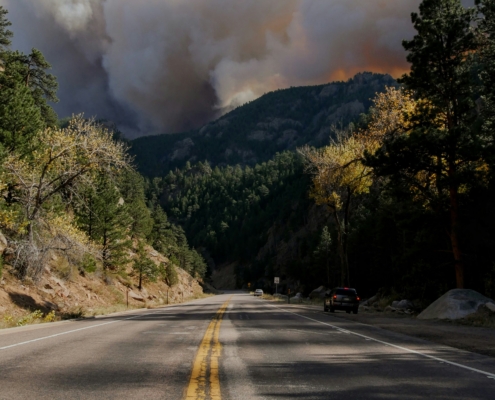 smoke coming up behind mountains because of a wildfire